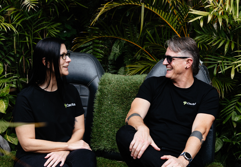 Maz Tait and Gareth Visser sitting together among plants